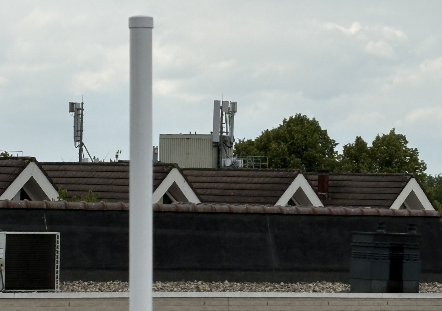 A nearby cellular site visible beyond the rooftop antenna